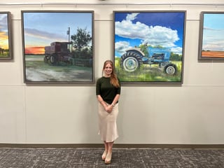 Artist standing next to painting