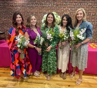 women with flowers posing for group photo